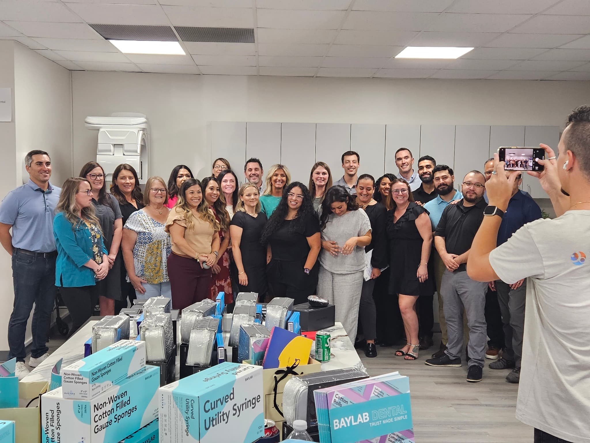 Clinical training area with cabinetry, imaging equipment, and dental professionals